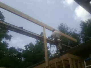 Carpenter setting a ridge beam over a new addition frame — Ice Dam Removal by Roofing Brothers in Elk Point