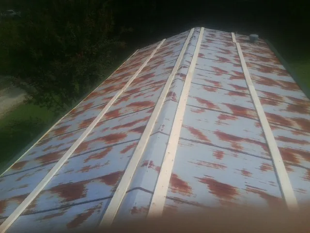 Rusted metal roof panels with new wood purlins before replacement — Storm Damage Roof Repair in Elk Point by Roofing Brothers
