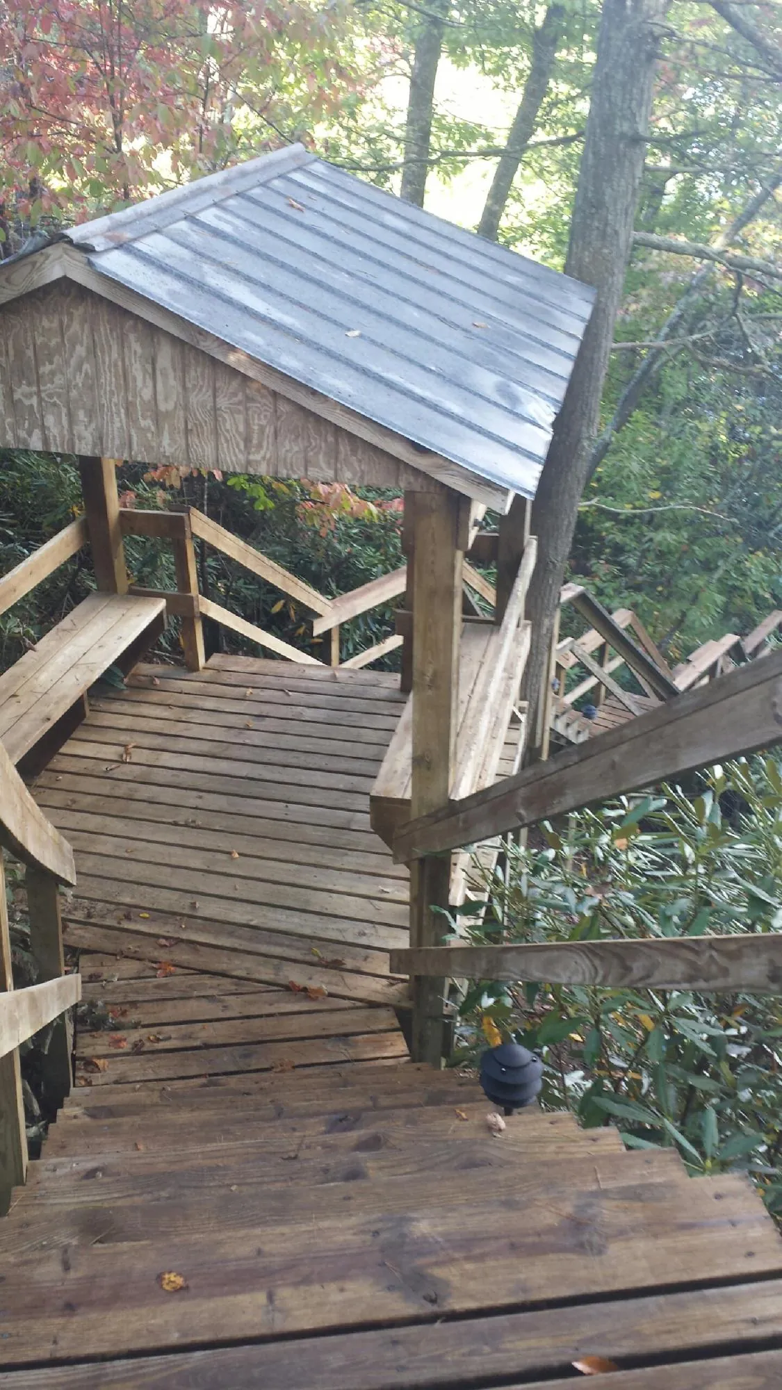 Metal roofed shelter over wooden steps on a wooded walkway — Skylight Repair & Installation work by our crew in Elk Point