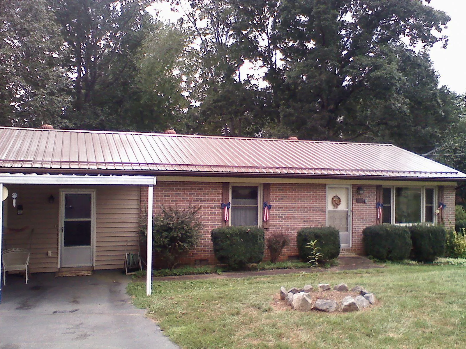 Bronze metal roof and carport on a brick ranch home — Roof Repair work by our crew in Elk Point